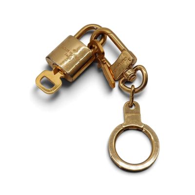 porte-clés plaqué or avec un cadenas sur fond blanc