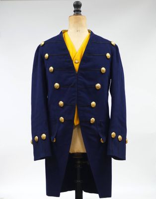 un gros plan d'un manteau posé sur un mannequin, lui-même placé sur un support