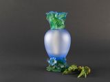 a blue vase with a green leaf on it