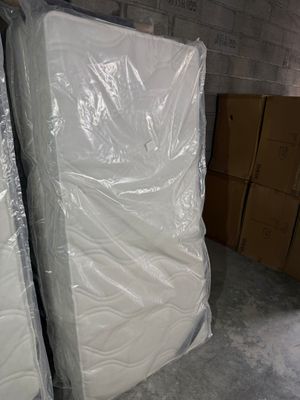 two mattresses that are wrapped in plastic in a room