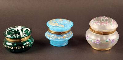 Trois petits récipients en verre sont posés les uns à côté des autres sur une table.