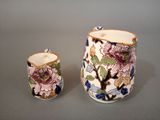 two pieces of pottery are sitting on a gray surface