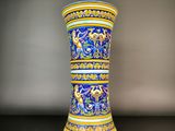 un vase bleu et jaune posé sur une table noire