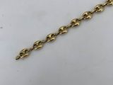 a close up of a gold chain on a white surface