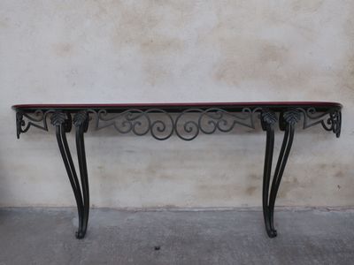 a black table with a red top sitting on a cement floor
