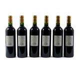 four bottles of wine are lined up in a row on a white surface