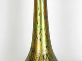 un vase en verre vert posé sur une surface blanche