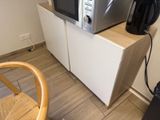 un micro-ondes posé sur un meuble, à côté d'une chaise