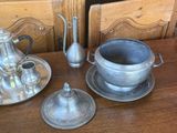 a silver tea pot and a silver plate on a wooden table