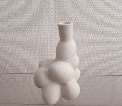 a white vase that has a bunch of white balls in it