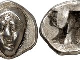 a close up of a coin with a face on it