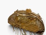 gold beaded purse on a white surface with a chain around it