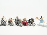 plusieurs figurines représentant des personnes à moto et des motos, posées sur une surface blanche