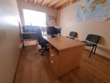 un bureau avec deux ordinateurs et une chaise dans une pièce