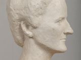 a white sculpture of a woman ' s head on a table