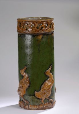 une image représentant un vase vert et marron orné de deux lapins