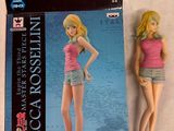 une poupée Barbie vêtue d'un haut rose et d'un short bleu, à côté d'une boîte de poupées Barbie