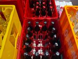 bottles of soda are in plastic containers on the floor of a boat