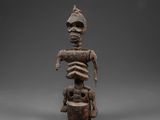 une statue en bois représentant un homme portant un casque sur la tête