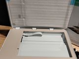 a white printer sitting on top of a table next to a green box