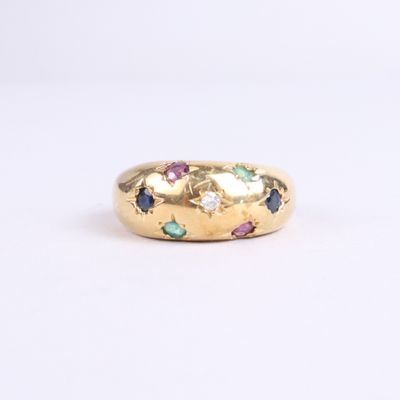 a close up of a gold ring with multi colored stones