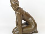 bronze statue of a woman kneeling on her knees