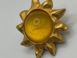 a close up of a sun shaped object on a white surface