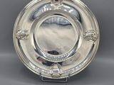 a silver plate with a lion head design on the rim