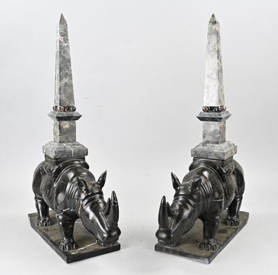 two statues of rhinos with a knife on top of them