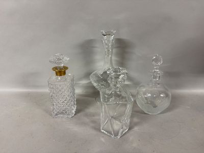 trois bouteilles en verre transparent et une petite bouteille en verre posées sur une surface blanche