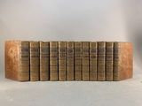 six old books stacked on top of each other in a row