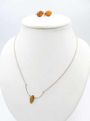 a close up of a necklace and earrings on a mannequin