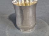 une tasse en argent posée sur une soucoupe
