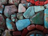 turquoise and red stones and a watch on display in a display case