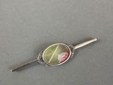 silver plated spoon with a green and pink flower on it