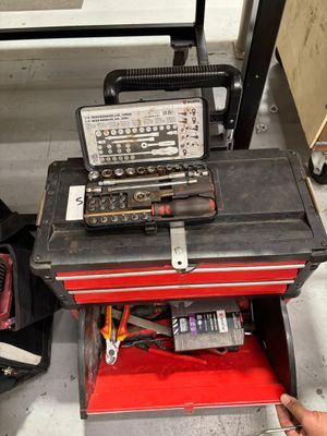 un homme qui tient une boîte à outils contenant des outils