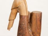 sculpture of a wooden duck on a white pedestal against a white background