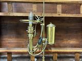 une lampe en laiton posée sur une étagère en bois
