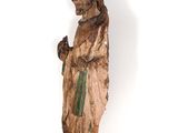 an old wooden statue of a man with a hat and a robe