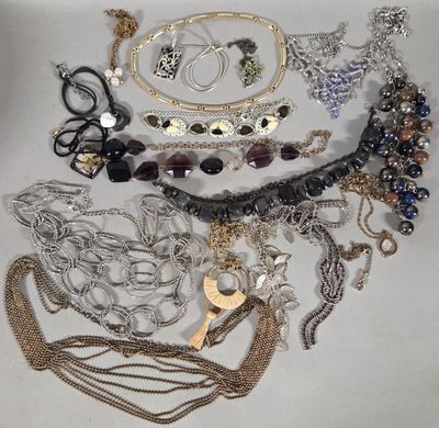 many different types of necklaces and bracelets laid out on a table