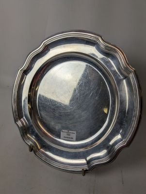 silver plate with a scalloped edge on a gray background