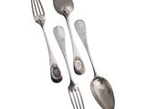 three spoons and two forks sitting next to each other