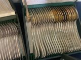 a lot of silver spoons and forks in a box