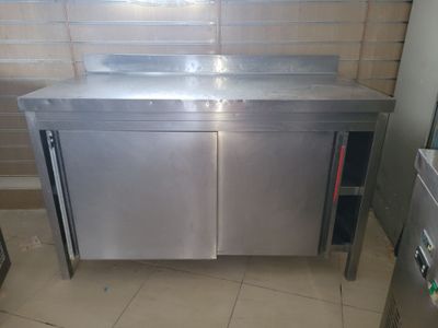 a stainless steel sink in a kitchen with a tiled floor
