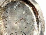 a silver plate that is sitting on a white surface