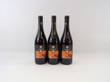 trois bouteilles de vin posées sur une table blanche