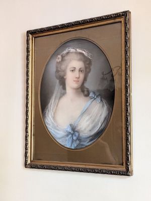 un tableau représentant une femme en robe bleue accroché au mur