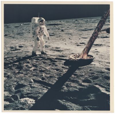 une vieille photo d'un astronaute debout sur la Lune, à côté d'une pelle