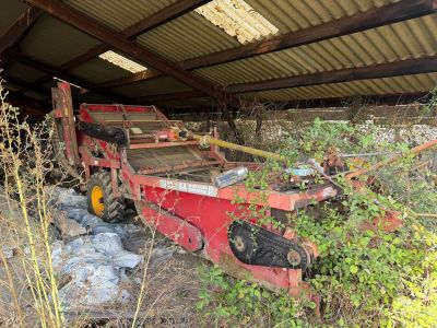 a large red machine that is sitting in the grass
