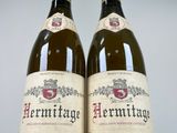 two bottles of wine sitting next to each other on a table